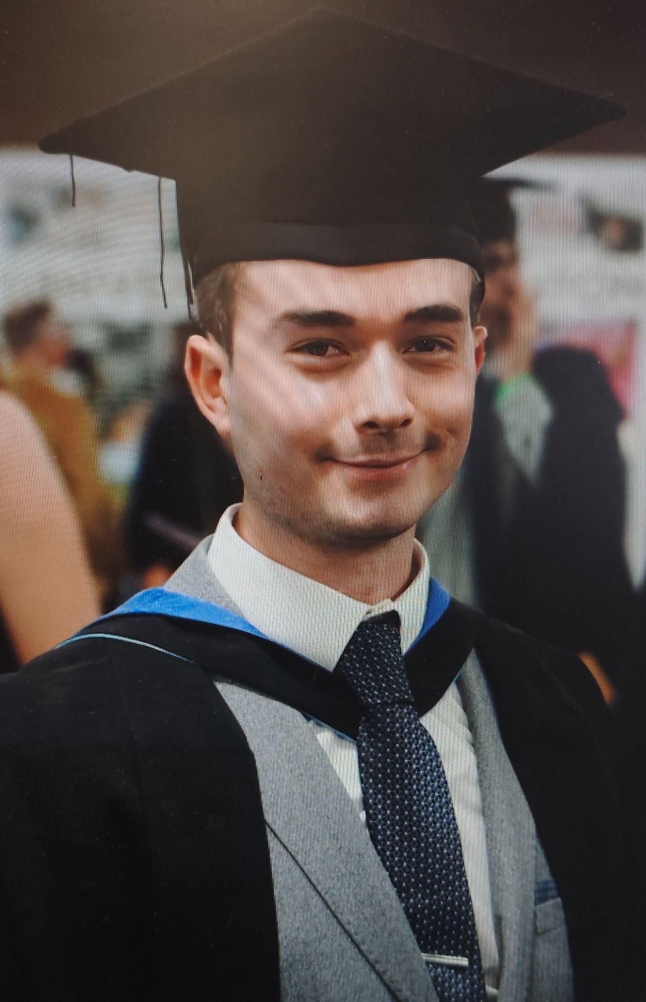 Tim in graduation robes receiving his award